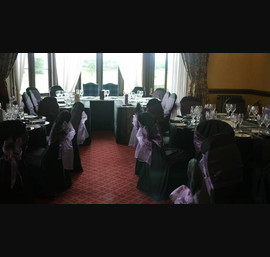 Black tablecloths & chair covers with heather bows at Matfen Hall