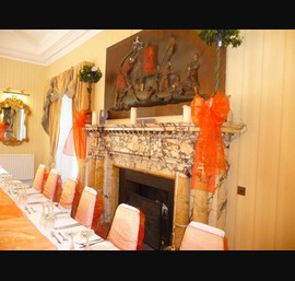 White Chair Covers and Orange Bows at Otterburn Towers