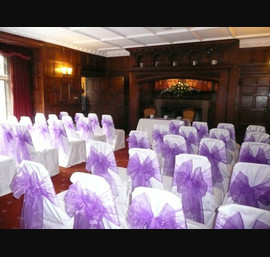 White Chair Covers and Purple Bows at Otterburn Towers