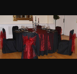 Ruby Red taffeta table runners with matching bows on black linen