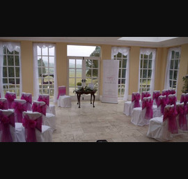 White Chair Covers and Bright pink bows at Woodhill Hall